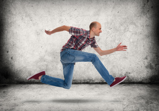 Man running. Gray concrete wall and floor